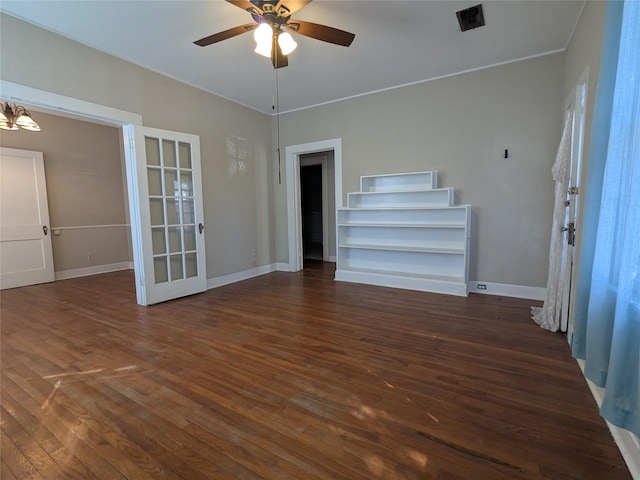 unfurnished living room featuring ceiling fan with notable chandelier and dark hardwood / wood-style floors