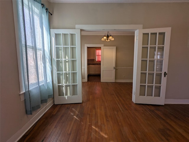 interior space with french doors, dark hardwood / wood-style flooring, and a chandelier