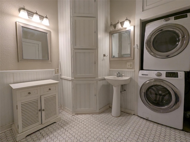 bathroom with wooden walls and stacked washing maching and dryer