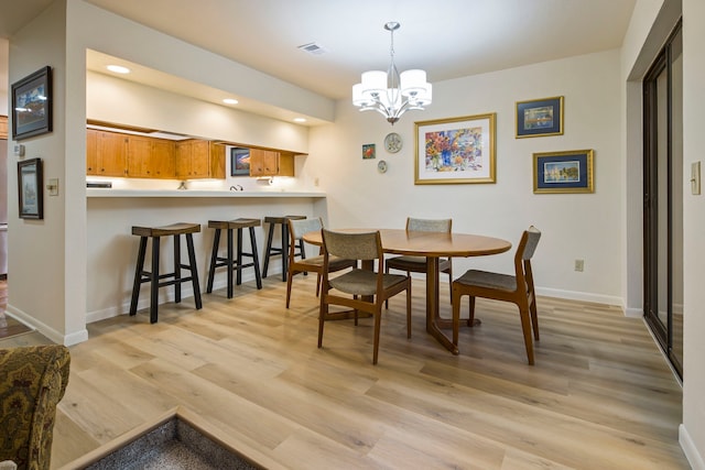 dining area featuring light hardwood / wood-style floors and a chandelier