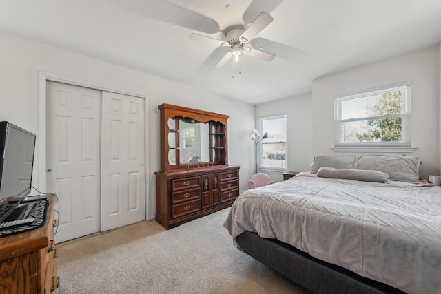 bedroom featuring light carpet, a closet, and ceiling fan