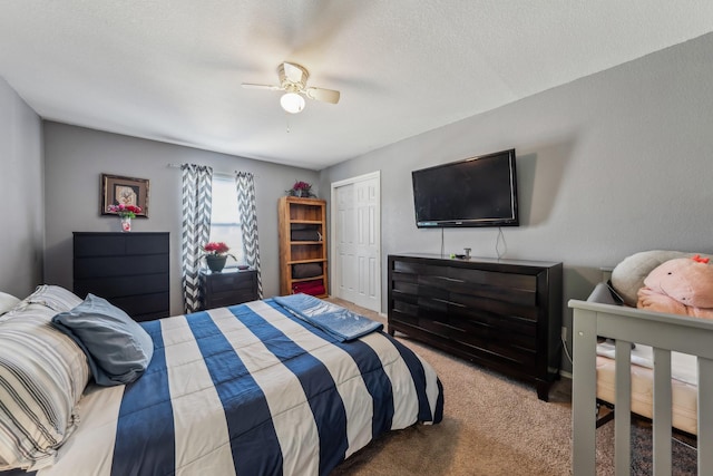 carpeted bedroom with a textured ceiling, ceiling fan, and a closet