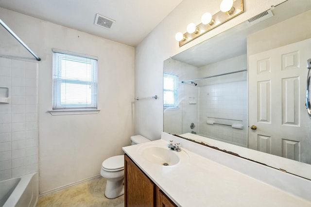 full bathroom featuring vanity, tiled shower / bath, and toilet