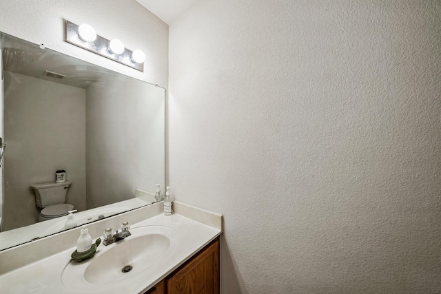 bathroom featuring vanity and toilet