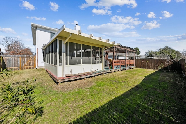 rear view of property featuring a pergola, a sunroom, and a lawn