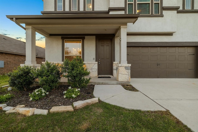 view of exterior entry featuring a garage and covered porch