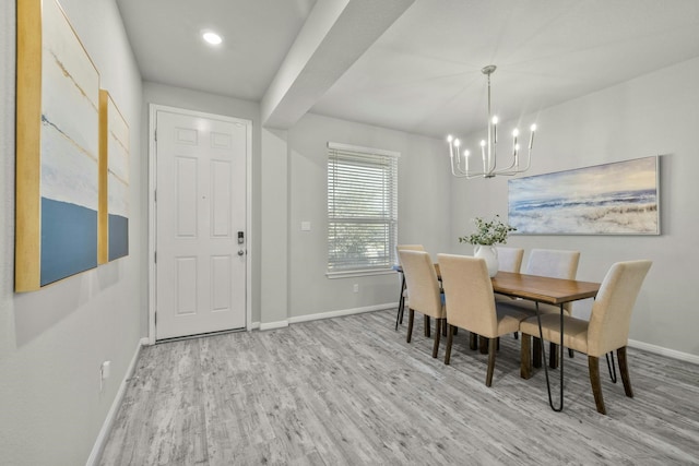 dining space with light hardwood / wood-style flooring and a notable chandelier