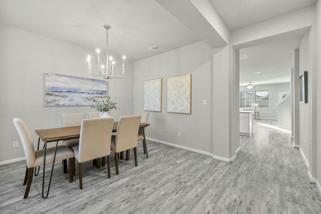 dining room with a chandelier and light wood-type flooring