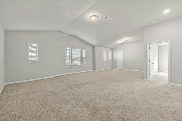 carpeted spare room with lofted ceiling