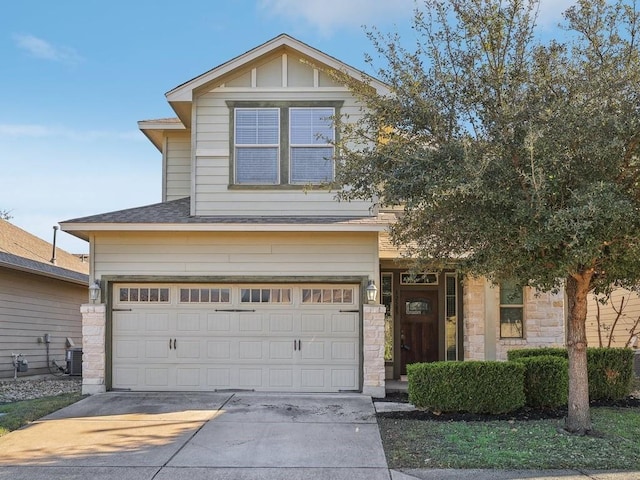 view of front of home with a garage and central AC