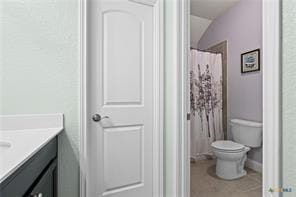 bathroom featuring walk in shower, vanity, and toilet