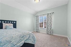 bedroom with vaulted ceiling and carpet flooring