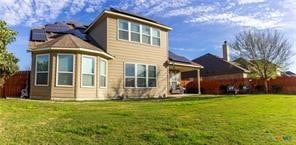 rear view of house featuring a lawn