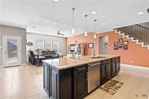 kitchen with sink, light tile patterned floors, a center island with sink, decorative light fixtures, and stainless steel dishwasher