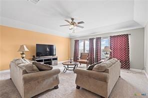 carpeted living room featuring a raised ceiling and ceiling fan