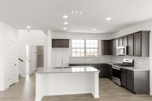 kitchen featuring dark brown cabinets, visible vents, a sink, and stainless steel appliances