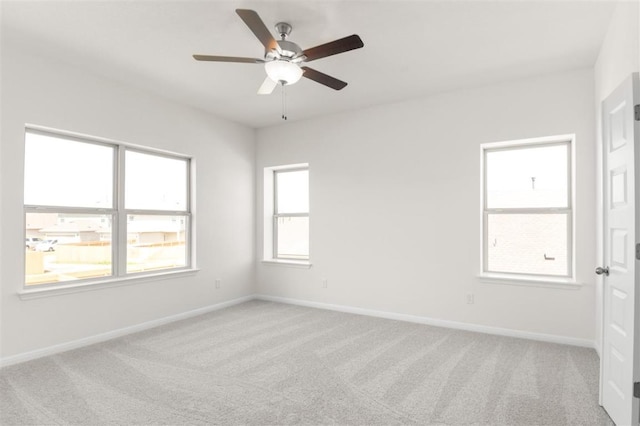 unfurnished room with a ceiling fan, carpet floors, and baseboards