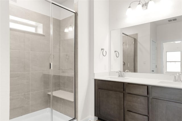 full bathroom featuring a stall shower, a wealth of natural light, and a sink