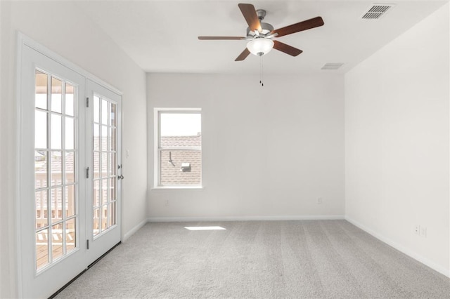 carpeted spare room with a ceiling fan, baseboards, and visible vents