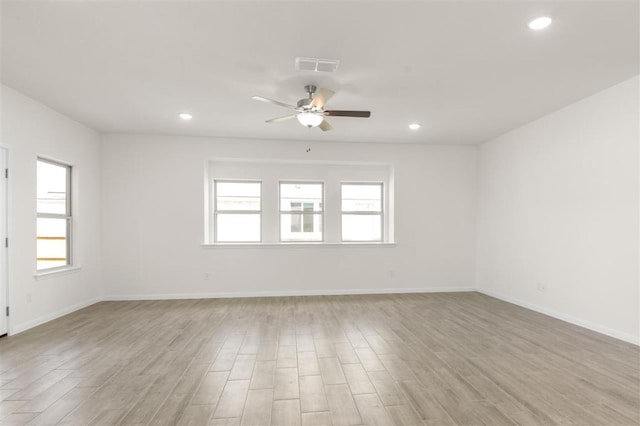 unfurnished room with visible vents, a healthy amount of sunlight, and light wood finished floors