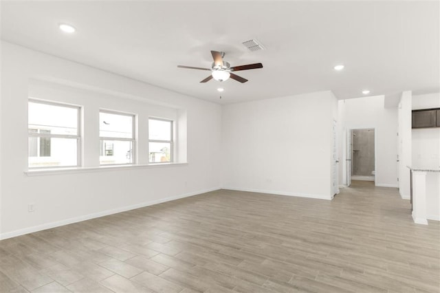 spare room with light wood-type flooring, a ceiling fan, recessed lighting, and a healthy amount of sunlight