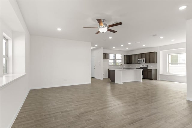 unfurnished living room with baseboards, recessed lighting, light wood-style floors, and a ceiling fan