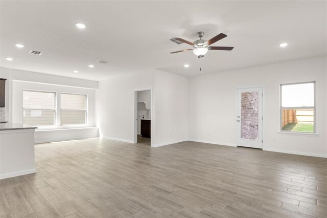 unfurnished living room with visible vents, light wood-style flooring, baseboards, ceiling fan, and recessed lighting