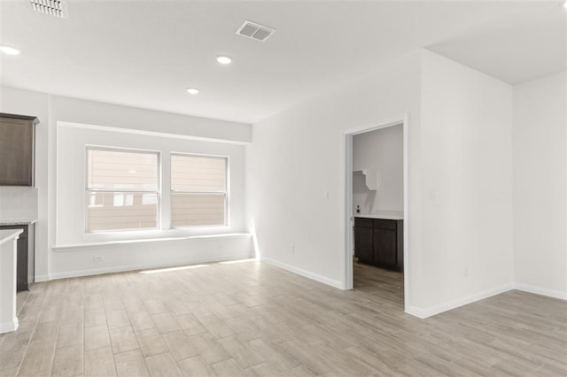 unfurnished living room featuring baseboards, visible vents, recessed lighting, and light wood finished floors