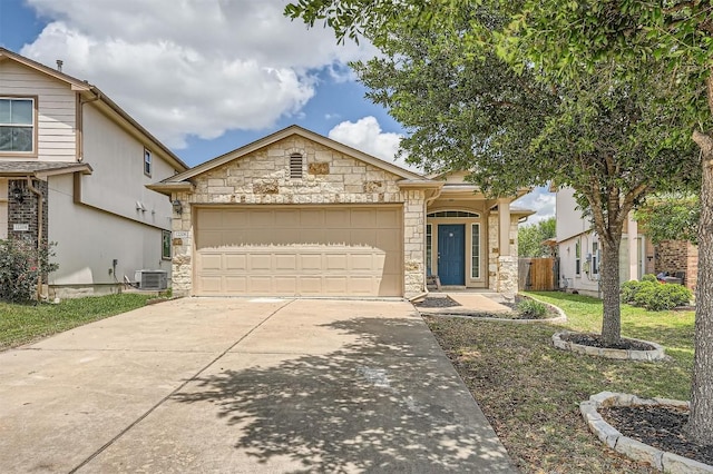 view of front of property with stone siding, an attached garage, driveway, and central AC unit
