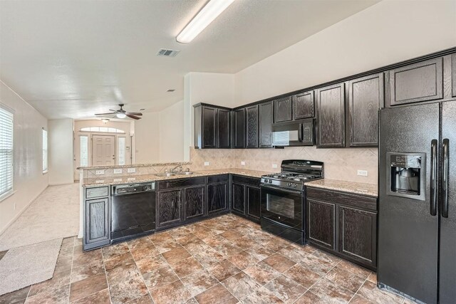kitchen with black appliances, a sink, backsplash, light stone countertops, and ceiling fan