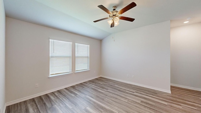 unfurnished room with lofted ceiling, ceiling fan, and light wood-type flooring