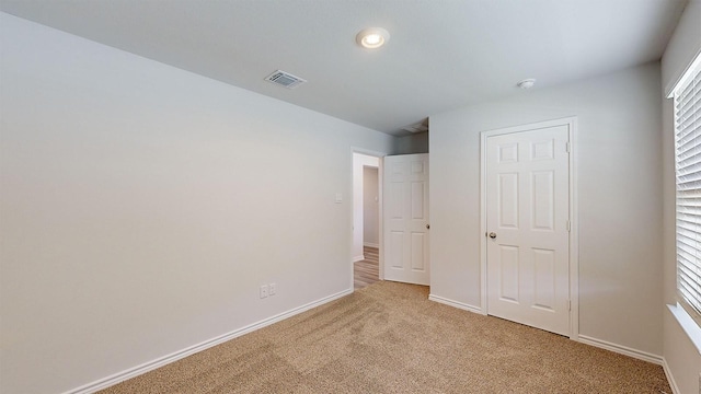 unfurnished bedroom featuring light carpet