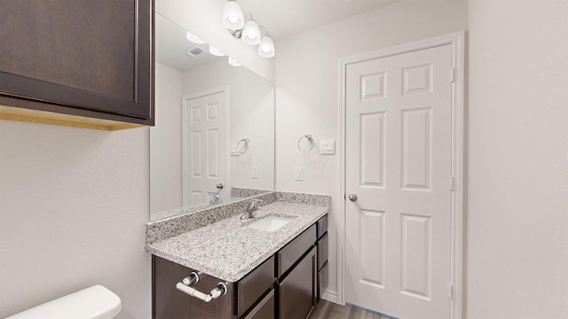 bathroom with vanity, hardwood / wood-style floors, and toilet