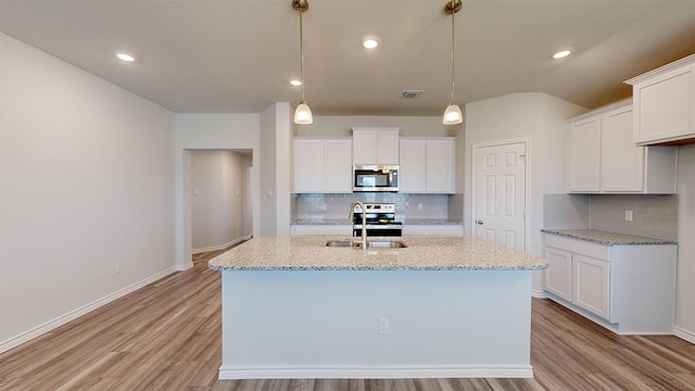 kitchen featuring stainless steel appliances, white cabinetry, tasteful backsplash, and pendant lighting