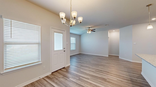 interior space featuring ceiling fan with notable chandelier and hardwood / wood-style floors