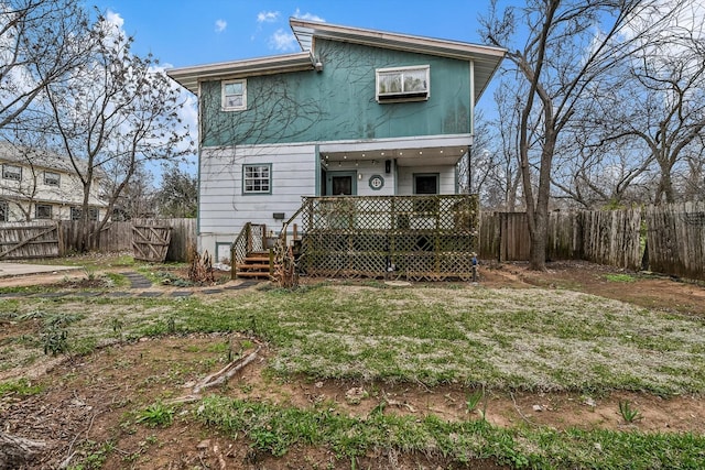 rear view of property featuring a wooden deck and a yard