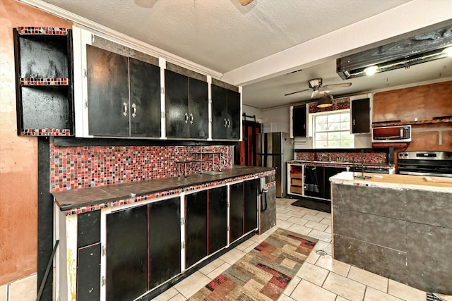 kitchen with light tile patterned floors, stainless steel appliances, a textured ceiling, and ceiling fan