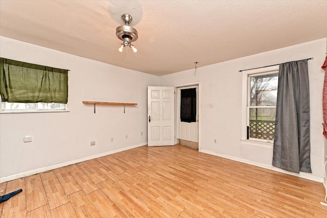 206 M L K Dr Unit B, Elgin, TX 78621 - spare room featuring wood finished floors, baseboards, and a textured ceiling