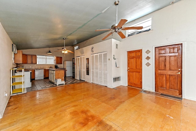 unfurnished living room featuring plenty of natural light, lofted ceiling, and ceiling fan