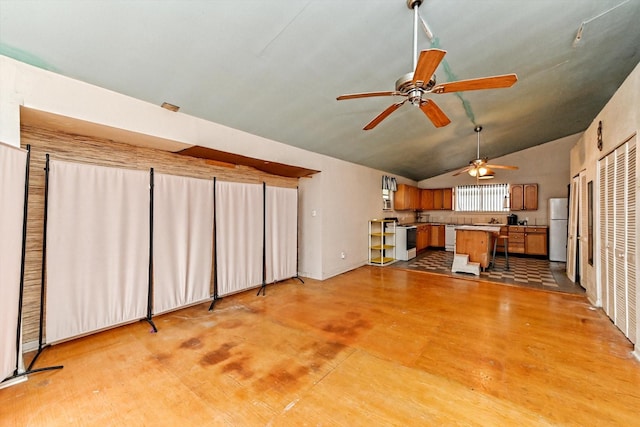 interior space with lofted ceiling, white appliances, and kitchen peninsula