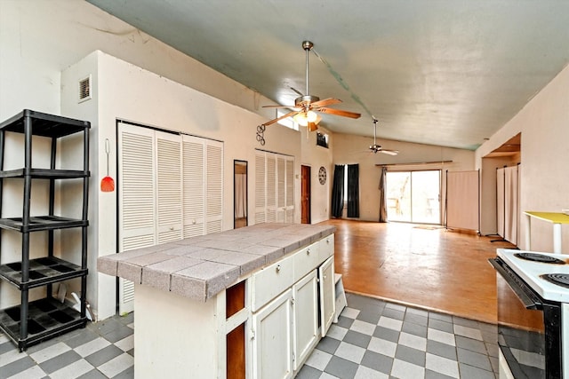 kitchen with electric range, vaulted ceiling, and white cabinets