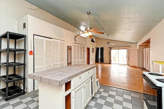 206 M L K Dr Unit B, Elgin, TX 78621 - kitchen with lofted ceiling, ceiling fan, tile countertops, white range with electric stovetop, and light floors