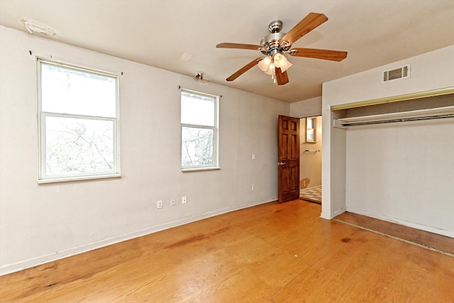 unfurnished bedroom featuring hardwood / wood-style flooring, ceiling fan, and a closet