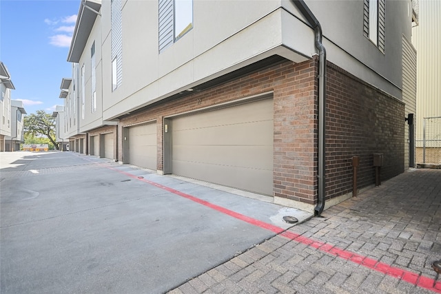 1702 S Lamar Blvd Unit 22, Austin, TX 78704 - view of home's exterior featuring an attached garage, brick siding, and driveway