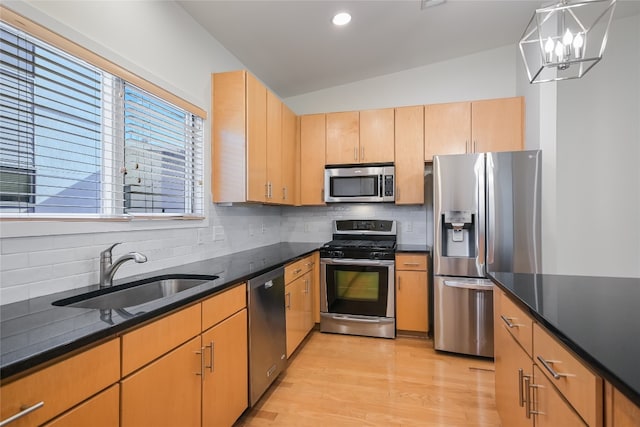 1702 S Lamar Blvd Unit 22, Austin, TX 78704 - kitchen with appliances with stainless steel finishes, backsplash, light wood-style floors, pendant lighting, and dark stone counters
