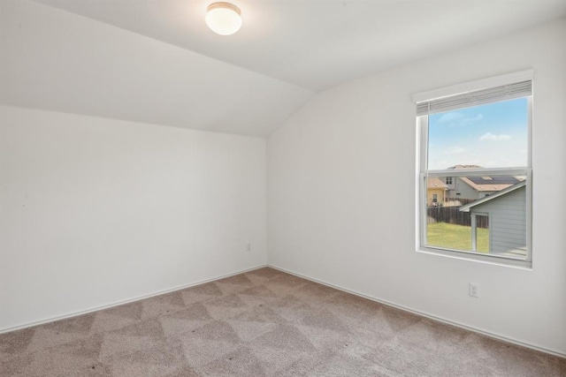 additional living space featuring light colored carpet, lofted ceiling, and plenty of natural light