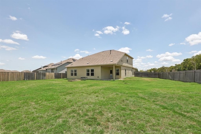 rear view of property with a yard