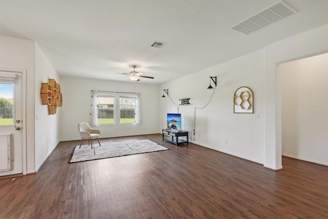 unfurnished living room with dark hardwood / wood-style floors and ceiling fan