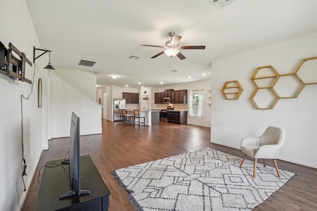 living room with dark wood-type flooring and ceiling fan