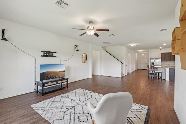 living room with ceiling fan and dark hardwood / wood-style flooring